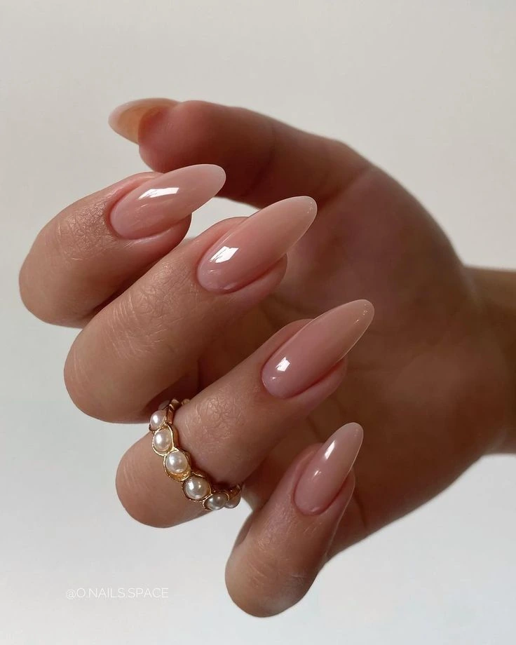 Nude acrylic almond nails with a pearl ring