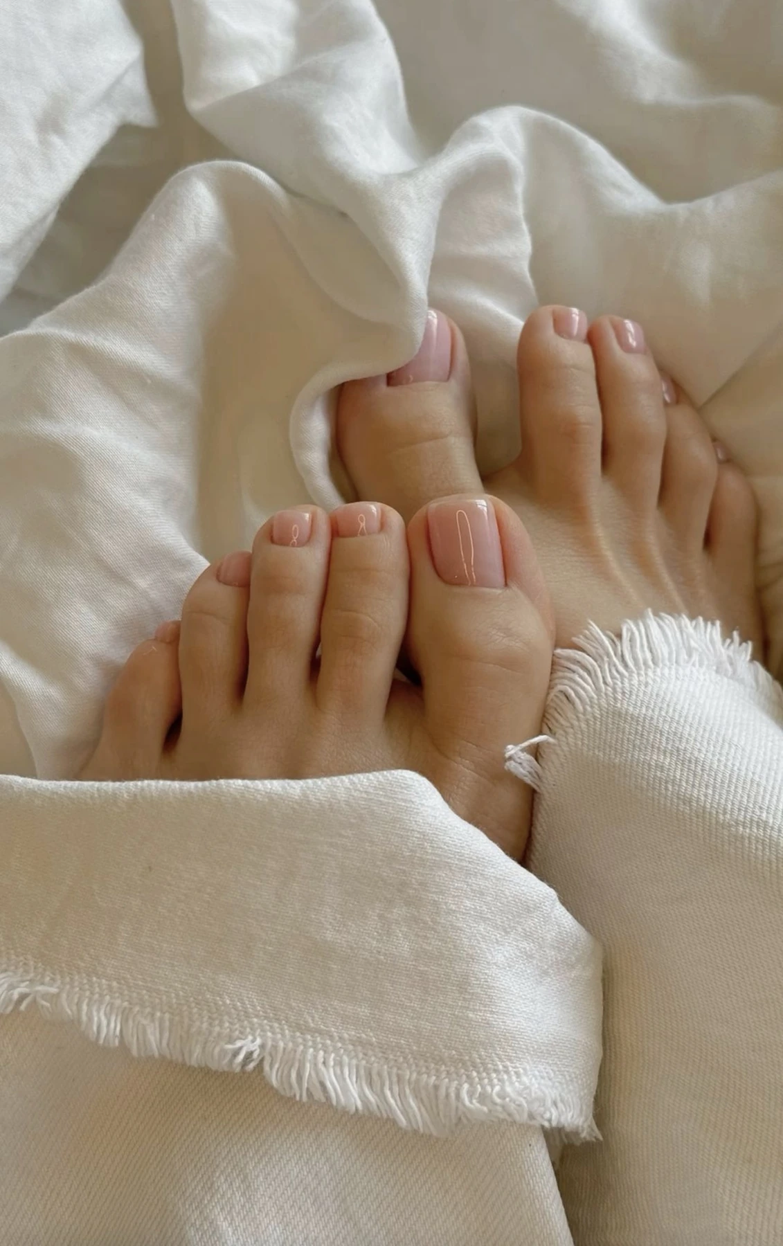 Natural nude pedicure with a fringed white towel