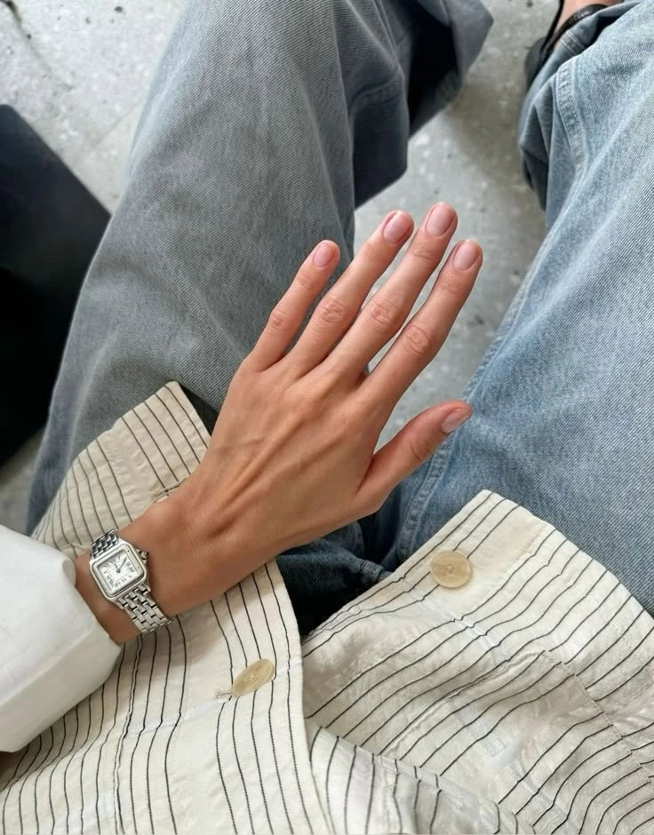 Natural nude manicure with a silver watch, striped shirt and denim